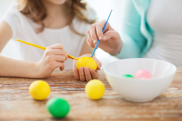 Close up of little girl and mother coloring eggs - Fotografie, Obrázek