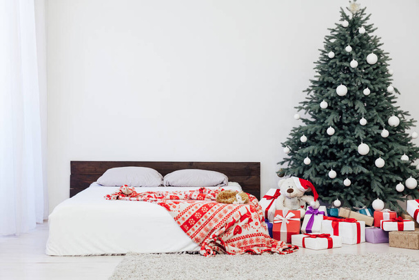 Kerstboom met cadeau decor slaapkamer met bed nieuwjaar feest winter achtergrond - Foto, afbeelding