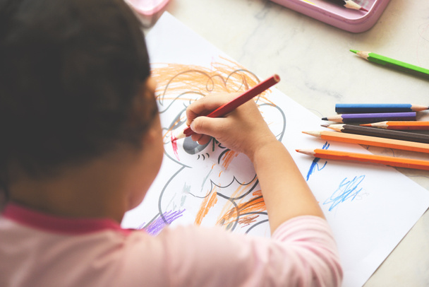 Gyermek lány festés papírlapon színes ceruzák a fa asztal otthon / Ismerje meg a gyerek csinál rajz kép és színes zsírkréta - Fotó, kép