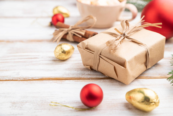 クリスマスまたは新年の組成物。白い木製の背景に装飾、箱、赤いボール、シナモン、モミやトウヒの枝、コーヒーカップ。サイドビュー、コピースペース、選択フォーカス. - 写真・画像