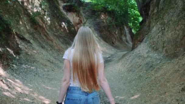 Вид ззаду красива блондинка, що йде в природному крихітному ворон
 - Кадри, відео
