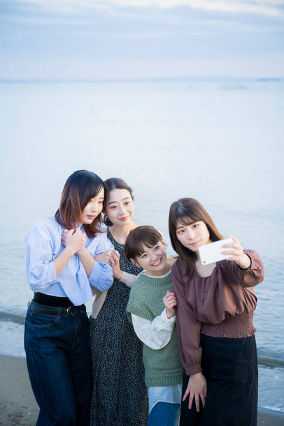 4 mladé ženy s pamětní fotkou s chytrým telefonem - Fotografie, Obrázek