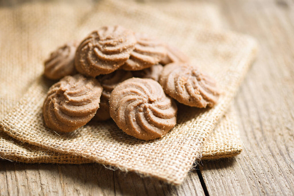 печенье шоколад на мешок и деревянный фон, мини печенье печенье печенья - Фото, изображение