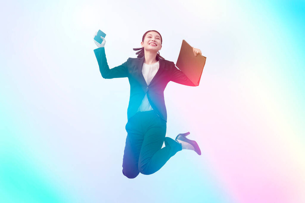 Een jonge zakenvrouw in een pak springt met een glimlach - Foto, afbeelding