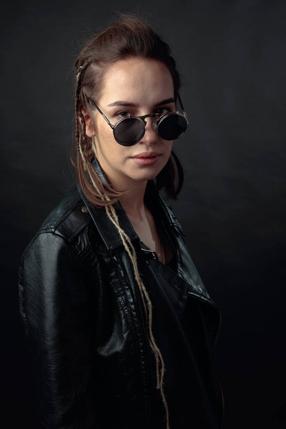 Красива стильна жінка в сонцезахисних окулярах в чорній шкіряній куртці
. - Фото, зображення