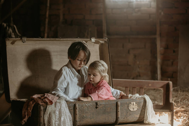 Little child, boy, hiding in old vintage suitcase in the attic, scared not to be found - Foto, imagen