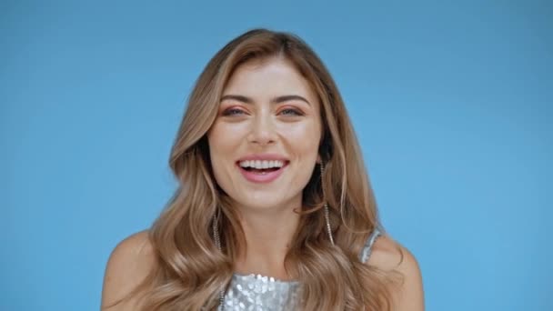 Γυναίκα γελάει ενώ κοιτάζει την κάμερα απομονωμένη στο μπλε  - Πλάνα, βίντεο