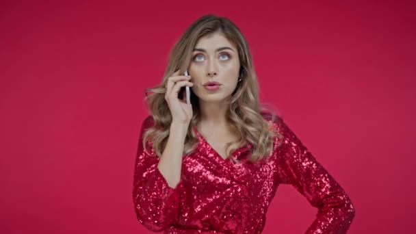 Mujer enojada hablando en el teléfono inteligente aislado en rojo  - Imágenes, Vídeo
