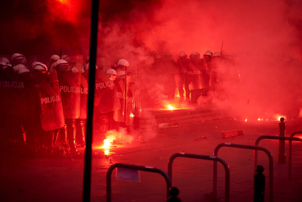Αστυνομικός κλοιός και κόκκινες φωτοβολίδες κατά τη διάρκεια διαδηλώσεων - Φωτογραφία, εικόνα