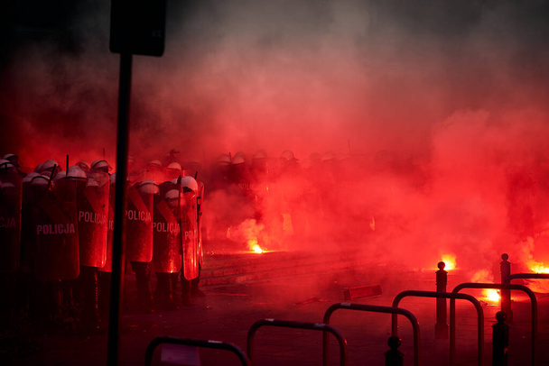 Αστυνομικός κλοιός και κόκκινες φωτοβολίδες κατά τη διάρκεια διαδηλώσεων - Φωτογραφία, εικόνα