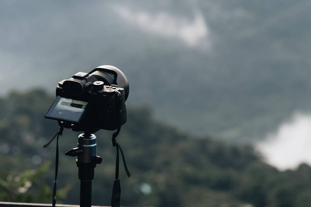 Camera on tripod making timelapse of panoramic view of mountain landscape - Photo, image