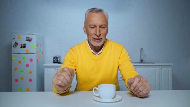 gelukkig man van middelbare leeftijd gebaren en praten tijdens skype call thuis - Video