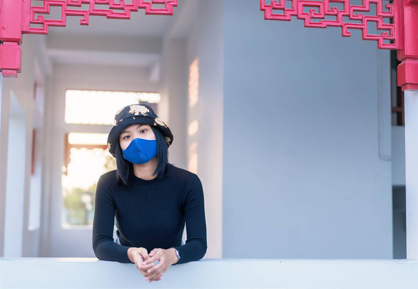 Koronavirüsten korunmak için koruyucu maske takan genç bir kadının portresi gün batımında iyi vakit geçirmeyi düşünüyor. Sağlık ve güvenlik hayatı kavramı COVID-19 koronavirüs salgını - Fotoğraf, Görsel