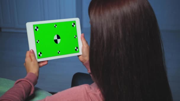 visão traseira da mulher morena segurando tablet durante a chamada skype em casa - Filmagem, Vídeo