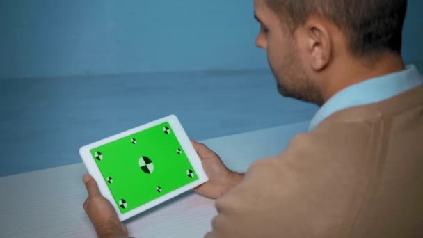 vista recortada del hombre sosteniendo tableta durante llamada skype en el interior - Metraje, vídeo