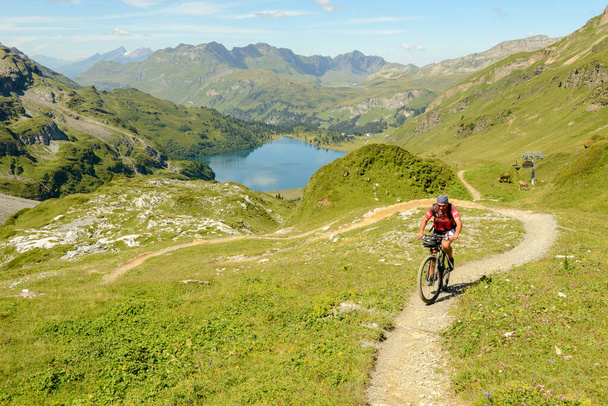 Jochpass, Швейцарія - 4 серпня 2018: людина на гірському велосипеді в протоці від Jochpass over Engelberg у Швейцарських Альпах - Фото, зображення