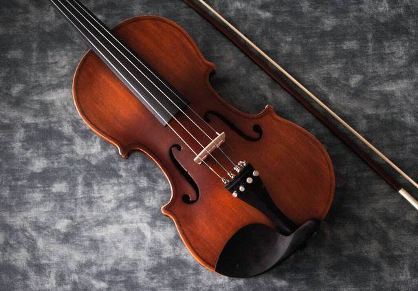 Violin front side put beside bow on background,show detail of acoustic instrument,vintage tone - Photo, Image
