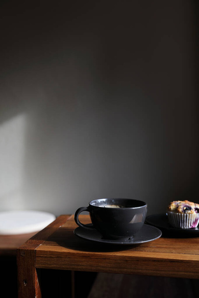 Coffee cup with muffin on wood table in local coffee shop - Fotoğraf, Görsel