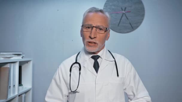 medico fiducioso con stetoscopio parlando durante la chiamata skype in ospedale - Filmati, video