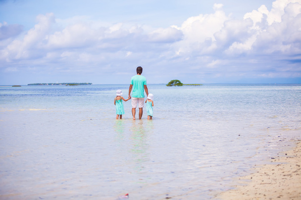Widok ładny mały ojciec dziewcząt i młodych chodzenie na egzotycznej wyspie z tyłu - Zdjęcie, obraz