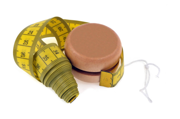 Concepto de dieta con yoyo y cinta adhesiva sobre fondo blanco - Foto, imagen