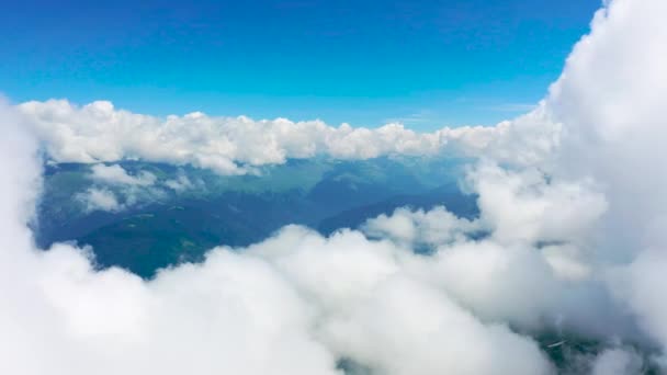 Kümülüs bulutları arasında bir dağ sırasının üzerinde uçuyor. - Video, Çekim