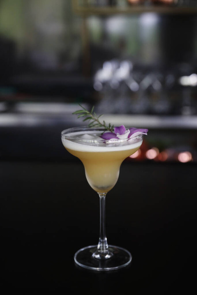 Gele Cocktailglas met ijs aan een bar - Foto, afbeelding