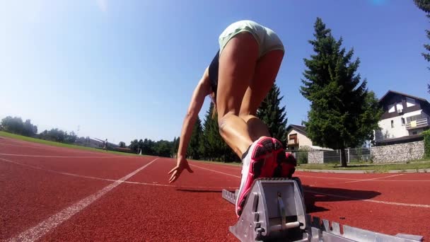 Mujer velocista iniciando un tablero de 100m de los bloques del velocista. Super slow motion - Imágenes, Vídeo