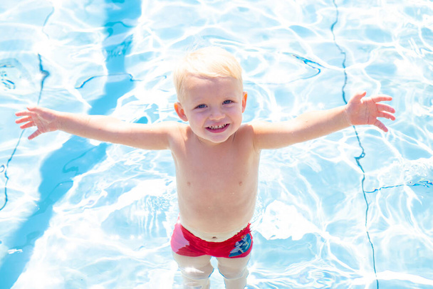 Child learning to swim in outdoor pool. Little child have fun on fresh air. Only fun is on my mind. - Zdjęcie, obraz