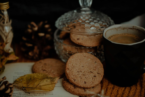 A closeup shot of tasty cookies and coffee in an autumn decoration set - Foto, imagen