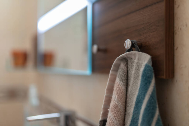 A towel hanging on a wooden board in the bathroom - Foto, imagen