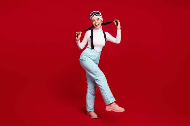 Full size photo of young beautiful attractive positive good mood girl hold ponytails enjoy weekend isolated on red color background - Fotografie, Obrázek
