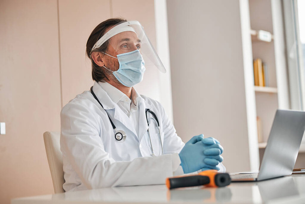 Профессиональный медик в маске и перчатках ждет посетителей - Фото, изображение