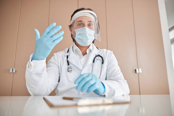 Figyelmes orvos egyéni védőfelszereléssel a munkahelyen - Fotó, kép