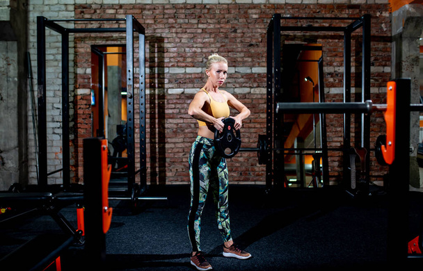 молодая женщина делает упражнения в тренажерном зале - Фото, изображение