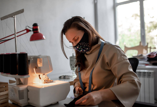menina costura máscaras na máquina de costura para proteger contra covid-19  - Foto, Imagem