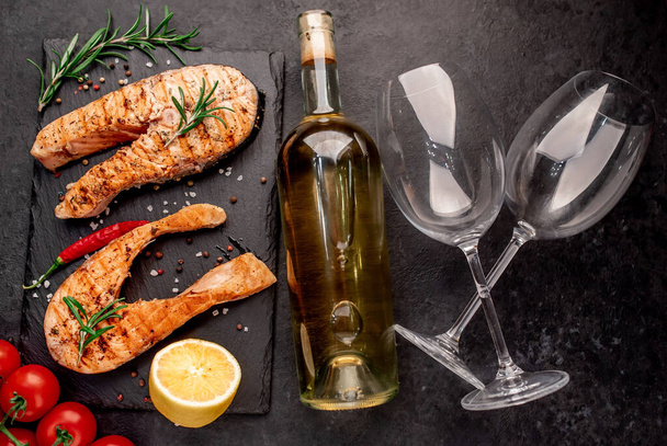 Dinner for two, salmon steaks and glasses for wine on stone background. - Fotoğraf, Görsel