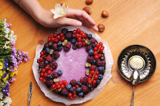 Festive cake, blueberry and blackberry sponge cake with cream cheese inside on a plate on a wooden table, horizontal view from above. - Photo, image