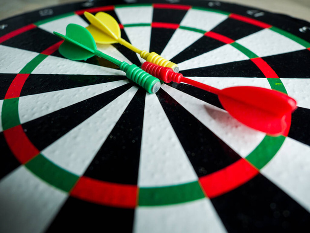 A closeup shot of three colored darts on a dartboard - Φωτογραφία, εικόνα