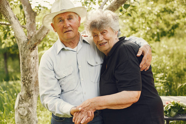 Beautiful old couple spend time in a summer garden - Valokuva, kuva
