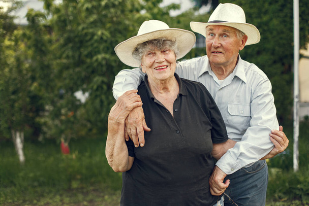 Hermosa pareja de ancianos pasar tiempo en un jardín de verano - Foto, Imagen