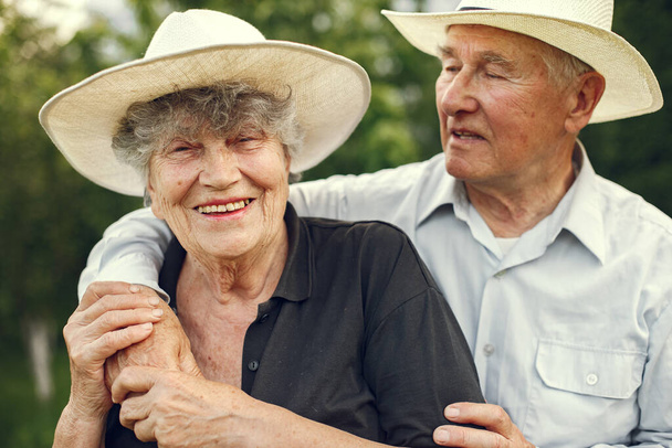 Beautiful old couple spend time in a summer garden - Valokuva, kuva