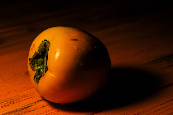 木製の背景においしい熟した柿の実。オレンジの背景に柿 - 写真・画像
