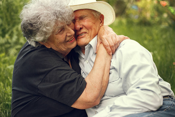 Beautiful old couple spend time in a summer garden - Photo, image