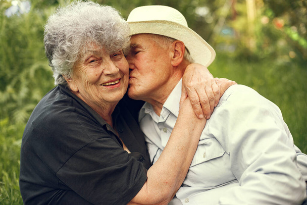 Beautiful old couple spend time in a summer garden - Fotografie, Obrázek