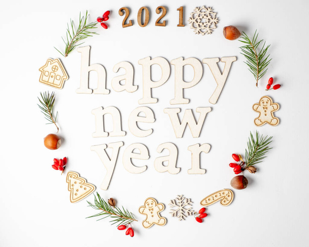  Christmas round frame, decorative border. Winter composition of numbers 2021, fir branches, red berries on a white background.Flat lay and copy space - Photo, Image