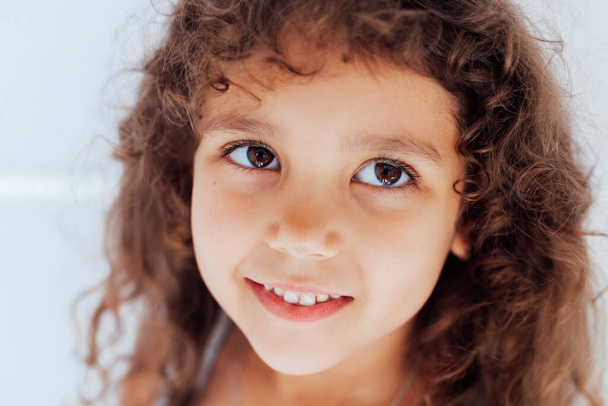 Hermoso pequeño rizado chica divertida retrato en blanco - Foto, imagen