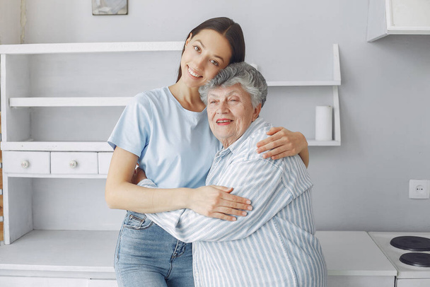 Old woman in a kitchen with young granddaughter - Photo, image