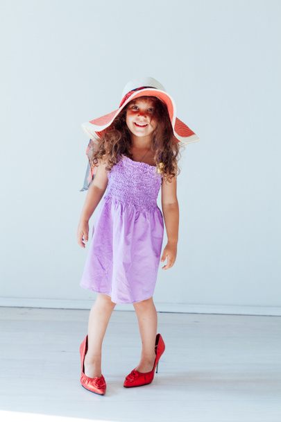 Beautiful little curly fashionable girl in moms shoes - Fotó, kép