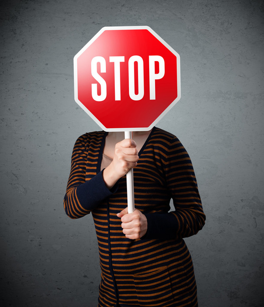 Young woman holding a stop sign - Foto, Bild